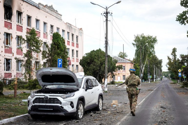 Террорист из ВСУ идёт по улице разорённого мирного города Суджа. Боевики Укро-Рейха вторглись в Курскую область как палачи и каратели